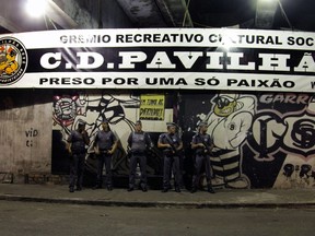 Policemen stand guard outside the Corinthians fans 'Hall 9' headquarters, in Vila dos Remedios, west of Sao Paulo after a shooting that left eight people dead oApril 19, 205. Seven members of organized Corinthians fans were executed within the place, and an eighth person was shot inside a gas station that is close to the crime scene, allegedly on drug-trafficking matters.  AFP PHOTO / BRAZIL PHOTO PRESS - FERNANDO NEVES