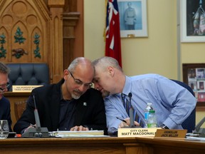 Chief administrative officer Rick Kester, left, Mayor Taso Christopher and clerk Matt MacDonald put their heads together to confer in the midst of talks about the city's operating budget last Thursday in Belleville.
