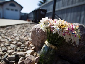 A bouquet of flowers is seen outside the house where 44-year-old Paula Stiles was found dead on April 15 in Sherwood Park, Alta., on Sunday April 19, 2015. RCMP continue to investigate the death as a homicide. Ian Kucerak/Edmonton Sun/Postmedia Network