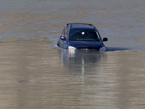 A vehicle sits in the North Saskatchewan River near the River Ridge Golf and Country Club, 5685 Windermere Blvd, in Edmonton, Alta. on Sunday April 19, 2015. David Bloom/Edmonton Sun/Postmedia Network