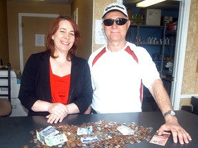 Salvation Army's Gerri St. Pierre accepts a donation of coins and bills from Jim Aubie. Aubie collected the money over the past 15 years as a Wallaceburg postman, as he looked for money on the ground as he walked along his route every day. He retired on April 1 and donated the found money to the Salvation Army.