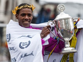 Lelisa Desisa of Ethiopia holds up the trophy after winning the 119th Boston Marathon. (David Butler II-USA TODAY Sports)