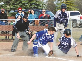 A Cardston player slides safely into home, with the ball not quite in Hawk catcher Jourdan Jones‘s glove, last Thursday during County Central High School senior varsity’s first game of the season, at the Virginia Mitchell Memorial Park.