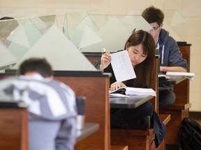 Second year Western University finance student Running Yang leafs through papers as she studies for exams at a booth in the social sciences building at Western University in London, Ont. on Monday April 20, 2015. (CRAIG GLOVER, The London Free Press)