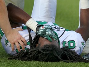 Saskatchewan Roughriders' Eddie Russ covers his eyes as training staff examine his injured leg during CFL action between the Riders and the Calgary Stampeders in Calgary on July 19, 2012. (JIM WELLS/CALGARY SUN)