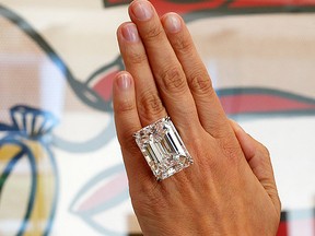 A woman displays a 100.20-carat diamond ring in front of Roy Lichtenstein's 1962 painting "The Ring (Engagement)" at a pre-auction viewing at Sotheby's in Los Angeles, Calif., in this file photo taken March 25, 2015. (REUTERS/Lucy Nicholson/Files)