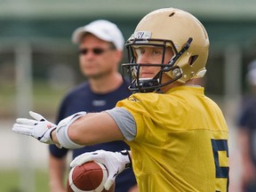 Winnipeg Blue Bombers offensive coordinator Marcel Bellefeuille, left, looks on as quarterback Drew Willy (5) passes during a CFL football workout at training camp Monday in Bradenton, Fla. (Steven Nesius/Postmedia Network)