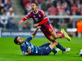 Bayern Munich’s Thiago Alcantara (top) is fouled by Porto’s Ivan Marcano during the Champion’s League quarterfinal match in Munich April 21, 2015. (Reuters/Michael Dalder)