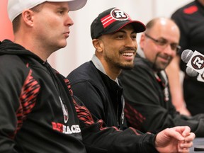 The Ottawa Redblacks newest signing, receiver Chris Williams, flanked by head coach Rick Campbell (L) and general manager Marcel Desjardins (R), smiles during a press conference at TD Place in Ottawa, Ont. on Tuesday April 21, 2015. Errol McGihon/Ottawa Sun/Postmedia Network