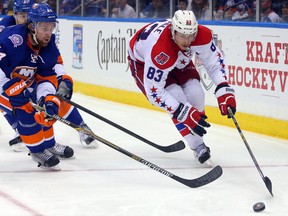Washington Capitals centre Jay Beagle controls the puck in front of New York Islanders defenceman Calvin de Haan during the third period of Game 4 of the first round of the 2015 NHL playoffs at Nassau Coliseum on April 21, 2015. (Brad Penner/USA TODAY Sports)