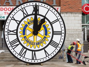 Don Swem and Ernie Houthuyzen look up at a 4.3 metre clock after attaching the hands before a crane hoisted the large timepiece into place above the front entrance of the Covent Garden Market. The clock, which marks the 100th anniversary of the Rotary Club of London - who donated $100,000 towards the $132,000 cost - was manufactured by Verdin Bells and Clocks of Cincinnati, Ohio, who also constructed the inner workings of the Peace Tower clock on Parliament Hill. (CRAIG GLOVER, The London Free Press)