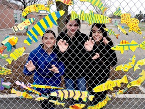 Princess Elizabeth public school students Angelina Kontitsis (Grade 5), left, Bella England (Grade 7) and Lorin Doski (Grade 7), stand next to an art project on their schoolyard fence April 21, 2015. Students participated in an educational program about water quality and the Upper Thames River Conservation Authority also announced The Sustainable Neighbourhood Retrofit Action Plan in the Glen Cairn neighbourhood. CHRIS MONTANINI\LONDONER\POSTMEDIA NETWORK