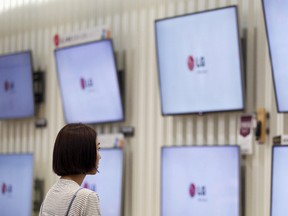 A customer looks at LG Electronics' television sets, which are made with LG Display flat screens, at its store in Seoul in this July 22, 2014 file photo. REUTERS/Kim Hong-Ji/Files