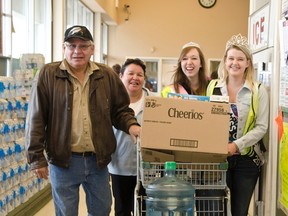 Miss Chimo Emma Blanchard helps carry John Archibald's and Charlene Echum's groceries with pagent princess Calie De Joesph during the girl's carry-out fundraiser for the Northern Ontario Families of Children with Cancer (NOFCC) at Valu-Mart on Thursday Apr. 16th.