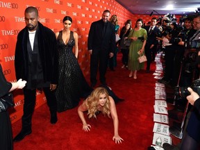 Honoree and Comedian Amy Schumer pretends to trip and fall on the floor  in front of honorees Kim Kardashian (2nd-L) and Kanye West (L) as they attend the Time 100 Gala celebrating the Time 100 issue of the Most Influential People at  The World at Jazz at Lincoln Center on April 21, 2015 in New York.  AFP PHOTO /  TIMOTHY  A. CLARY