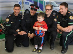 From left, paramedic Robin Thenu, Const. Seth Dodman, and paramedics Brendan Mulholland and Sean Vesak pose for a picture with Talon Smith-Nelson, 4. The four  saved Smith-Nelson's life after he was born on May 5, 2010 at just 24 weeks. They didn't know Smith-Nelson survived until a month ago. They were all reunited on Wednesday, April 22, 2015 at the Bonnie Doon EMS Station in Edmonton, Alberta. CLAIRE THEOBALD/Edmonton Sun