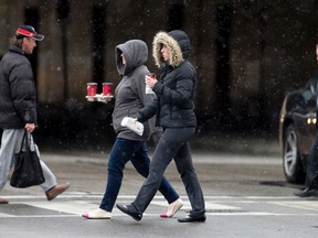 Pedestrians brave a mix of rain and snow as they cross London?s King St. on a chilly coffee run Wednesday. Today?s forecast calls for cloud and a high of 3 C. (CRAIG GLOVER, The London Free Press)