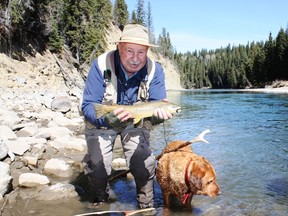 Neil with his fox red Lab Penny with a Clearwater River brown trout.