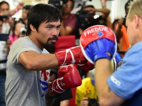 Manny Pacquiao (left) spars with his coach, Freddy Roach, ahead of his upcoming fight against Floyd Mayweather during a training session at the Wild Card Boxing Club in Hollywood April 15, 2015. (AFP PHOTO/FREDERIC J. BROWN)