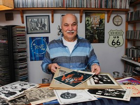 Larry Stafford, local musician and sound engineer, shows a few of the vintage band photographs he has in his extensive collection at his home in Kingston. (Julia McKay/The Whig-Standard)