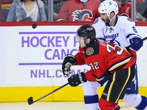 Calgary Flames centre Paul Byron (32) and Tampa Bay Lightning defenceman Jason Garrison battle for the puck during NHL play this season at Scotiabank Saddledome. (Sergei Belski/USA TODAY Sports)
