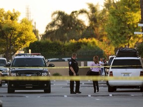 A police officer and residents are seen at the crime scene where mayor of Bell Gardens, California Daniel Crespo was shot, at a condominium in Bell Gardens, California September 30, 2014. (REUTERS/Bob Riha)