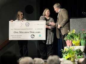 Katie Shillington helps Sr. Sheila McKinley present a $1-million cheque to Ray Power, principal of Ursuline College Chatham on Thursday.
(Thomas Surian/The Daily News)