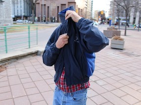 OTTAWA - April 23, 2015 - Conrad Eagan leaves the courthouse with his face covered late afternoon on Wednesday, April 22, 2015, after his release on bail. Eagan faces fraud, breach of trust and other related charges after allegedly bilking seniors — including his own grandmother — of hundreds of thousands of dollars. (TONY SPEARS/Ottawa Sun/Postmedia Network)