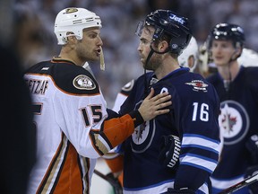Winnipeg Jets captain Andrew Ladd (right) and Anaheim Ducks captain Ryan Getzlaf shake hands after the end of their NHL playoff series in Winnipeg on Wed., April 22, 2015. Kevin King/Winnipeg Sun/Postmedia Network