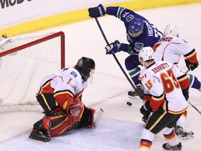 Calgary Flames goalie Jonas Hiller eyes puck-handling Vancouver Canucks forward Chris Higgins during Game 5 of a first-round 2015 NHL playoffs series at Rogers Arena on April 23, 2015. (Carmine Marinelli/Postmedia Network)