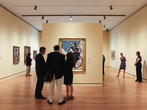 Guests observe Norman Rockwell's 1943 oil on canvas painting 'Rosie the Riveter', centre, while touring the Crystal Bridges Art Museum, in Bentonville, Ark., in this May 31, 2012 file photo. (REUTERS/Jacob Slaton)