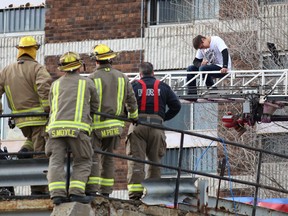 Wendell Bondy sits on an aerial ladder as Greater Sudbury Police negotiate his surrender at an apartment on the Lloyd Street hill in Sudbury, Ont. on Thursday April 23, 2015. John Lappa/Sudbury Star/Postmedia Network