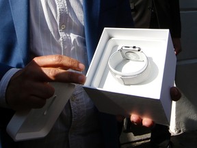 A customer opens the package containing his Apple Watch after buying it at a store in Paris, France, April 24, 2015. REUTERS/Benoit Tessier