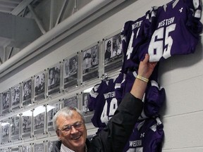 Bill Imrie, St. Thomas, unveils his plaque during induction to the Mustangs Football Wall of Champions as a player and winning coach. Also honoured were the 1949 football squad which included three St. Thomas players.