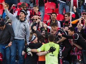 Ottawa Fury FC players celebrate in the stands with fans following their defeat of the Minnesota United FC during the Fury NASL home opener at TD Place in Ottawa on Saturday April 18, 2015. Errol McGihon/Ottawa Sun/Postmedia Network