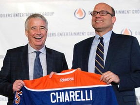 Oilers Entertainment Group chief executive Bob Nicholson presents the Edmonton Oilers new President and General Manager Peter Chiarelli with a jersey during a press conference at The Fairmont Hotel Macdonald, in Edmonton, Alta. on Friday April 24, 2015. David Bloom/Edmonton Sun/Postmedia Network