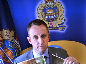 Det. Rae Gerrard, pictured, of the Criminal Investigations Section is holding up photos that demonstrate the effort the suspects took to gain entry into the jewelry store. Photo Supplied  Edmonton Sun/Postrmedia