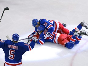 New York Rangers left winger Carl Hagelin is congratulated by teammates Dominic Moore and Dan Girardi after scoring the game winning goal against the Pittsburgh Penguins in Game 5 of the first round of the 2015 NHL playoffs at Madison Square Garden on April 24, 2015. (Adam Hunger/USA TODAY Sports)