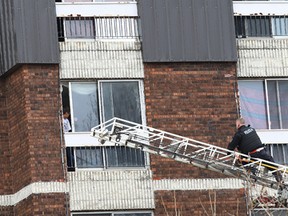 Police uses an aerial ladder to get closer to an apartment where a young man involved in a standoff looks out of a window on the Lloyd Street hill in Sudbury, Ont. on Thursday April 23, 2015. John Lappa/Sudbury Star/Postmedia Network