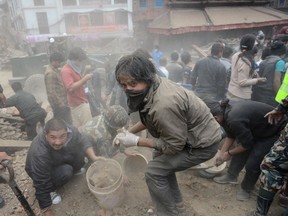 People clear rubble in Kathmandu's Durbar Square, a UNESCO World Heritage Site that was severely damaged by an earthquake on April 25, 2015. A massive 7.8 magnitude earthquake killed hundreds of people April 25 as it ripped through large parts of Nepal, toppling office blocks and towers in Kathmandu and triggering a deadly avalanche that hit Everest base camp. AFP PHOTO / PRAKASH MATHEMA