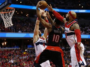 Raptors guard DeMar DeRozan shoots the ball as Wizards forward Drew Gooden (right) and centre Marcin Gortat try to make the block during fourth-quarter action in Game 3. (USA TODAY SPORTS/PHOTO)