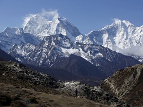 A trekker walks in front of Mount Thamserku while on his way back from Everest base camp near Pheriche in Solukhumbu District, in this file picture taken May 3, 2014. A major earthquake in Nepal on April 25, 2015 unleashed an avalanche on Mount Everest, killing at least eight people and raising fears for other climbers on the world's highest peak, a tourism ministry official said.  REUTERS/Navesh Chitrakar