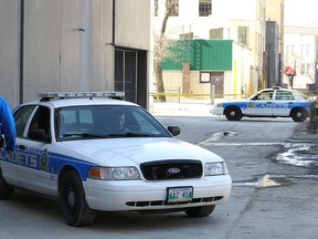 Winnipeg police vehicles are stationed on Ellice Avenue and a backlane between Hargrave and Donald streets on Sat., April 25, 2015, after the body of an elderly person was discovered in the area early Saturday morning. The homicide unit is investigating. Kevin King/Winnipeg Sun/Postmedia Network