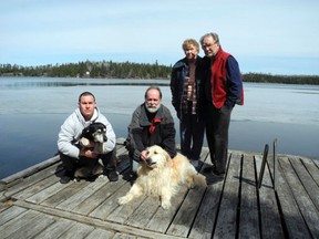 Nash Prystie and his dog Buddy (left) are joined by rescuers Rick Browning and Ollie, grandparents Harold and Linnea Prystie; not pictured, Linda Prystie. The dramatic life saving rescue took place in the open water pictured behind the group in front of Browning’s island cabin on Ena Lake, north of Kenora.