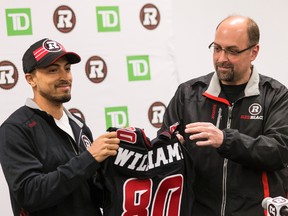 The Ottawa Redblacks newest signing, receiver Chris Williams (L), gets his jersey from general manager Marcel Desjardins during a press conference at TD Place in Ottawa, Ont. on Tuesday April 21, 2015. Errol McGihon/Ottawa Sun/Postmedia Network