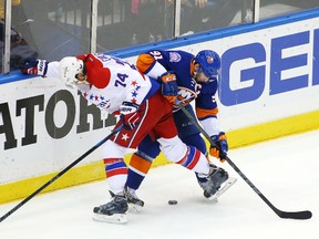 Washington Capitals defenceman John Carlson and New York Islanders centre John Tavares battle for a loose puck during the first period in game six of the first round of the 2015 Stanley Cup Playoffs at Nassau Veterans Memorial Coliseum on April 25, 2015. (Andy Marlin/USA TODAY Sports)