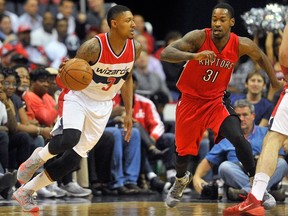 Wizards’ Bradley Beal (left) handles the ball against Raptors’ Terrence Ross on Sunday night in Washington. (AFP/PHOTO)
