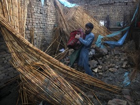 A man collects belongings from his house partially-destroyed following heavy rain in the outskirts of Peshawar, Pakistan, April 27, 2015. (REUTERS/Fayaz Aziz)