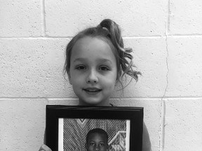 St. Anthony Catholic School Grade 3 student Drew Cropley shows off the photo of Anita Nyaaba, a Grade 2 student from Awaso, Ghana, Africa. Cropley sponsors Nyaaba to go to school.