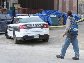 A man walks behind Siloam Mission in Winnipeg, Man. Monday April 27, 2015 as Winnipeg Police seize several dumpsters possibly connected to the murder of two homeless men over the weekend.
Brian Donogh/Winnipeg Sun/Postmedia Network